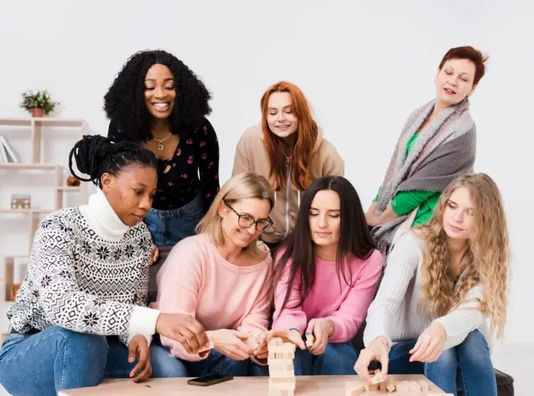 A diverse group of young friends laughing and playing a tabletop game together.