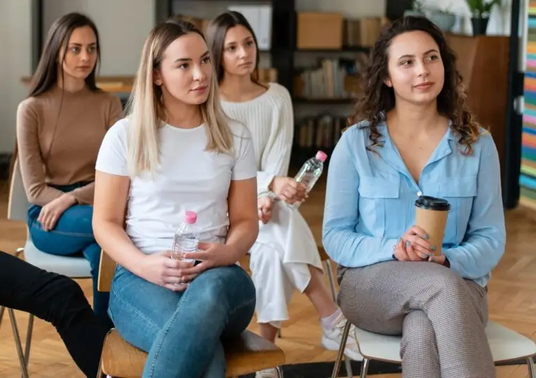 A group of young women sitting together and listening attentively during a meeting.